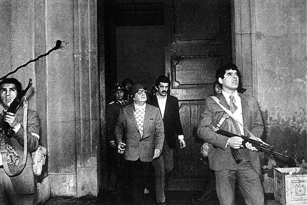 Chilean Socialist President Salvador Allende (3R wearing helmet) stands accompanied by bodyguard as Augusto Pinochet''s coup forces pressed their armed siege against the La Moneda presidential palace in Santiago September 11, 1973. While the rest of the world remembers the attacks on New York and Washington, Chileans mark their own September 11, the 1973 military coup that 31 years later still scars the national soul. A military junta took power, ushering in the 17-year dictatorship of Augusto Pinochet , whose so-called dirty war claimed some 3,000 lives. REUTERS/Danilo Bartulin/FILE CHILE ANNIVERSARY