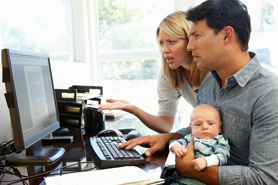Couple working in home office with baby