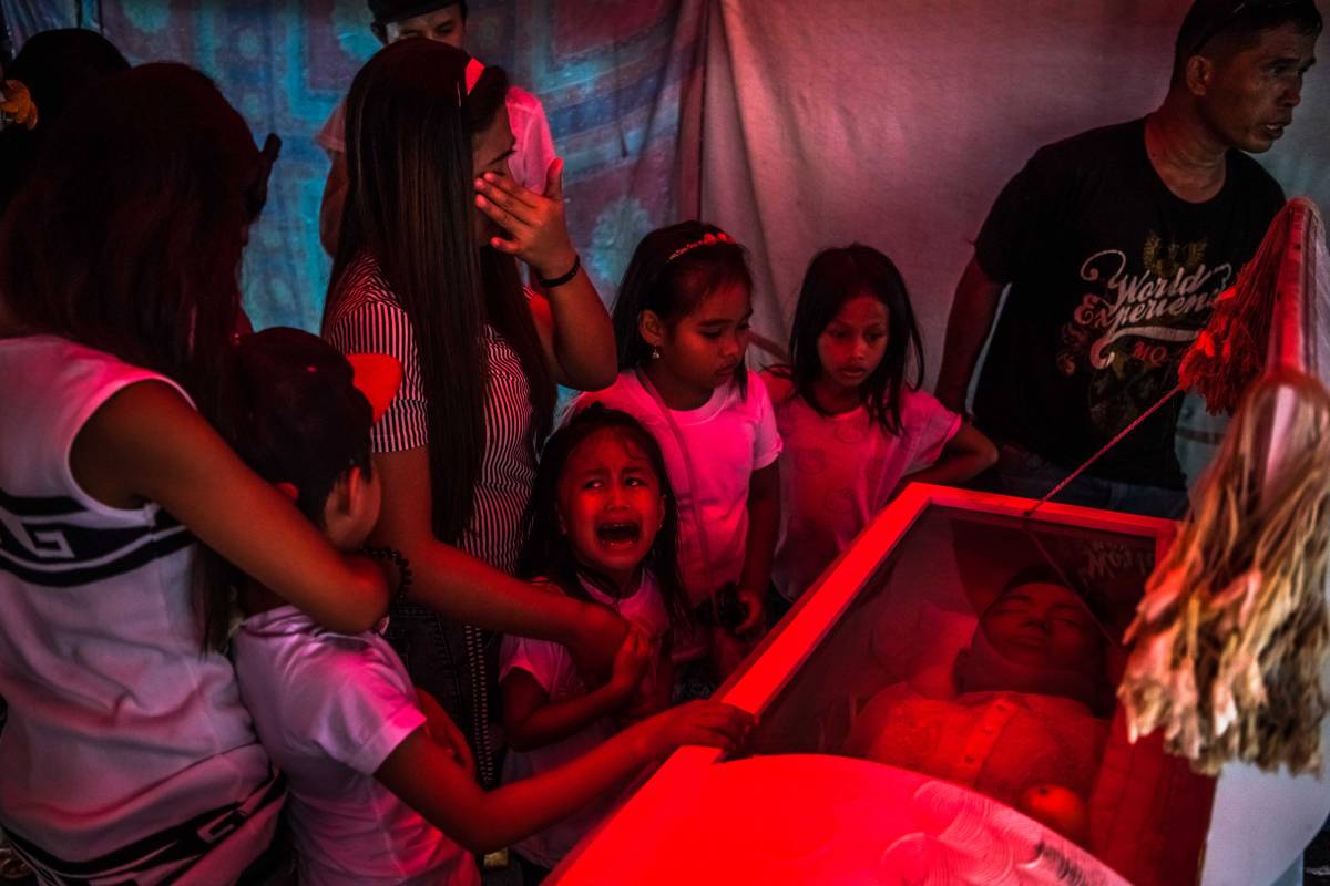 Jimji, 6, cries out in anguish, saying "Papa" as workers move the body of her father, Jimboy Bolasa, 25, for burial, in Manila, Philippines, Oct. 9, 2016. Bolasa was found murdered along with his neighbor. A bloody and chaotic campaign against drugs that President Rodrigo Duterte began when he took office on June 30 has seen about 2,000 people slain at the hands of the police alone. (Daniel Berehulak/The New York Times)