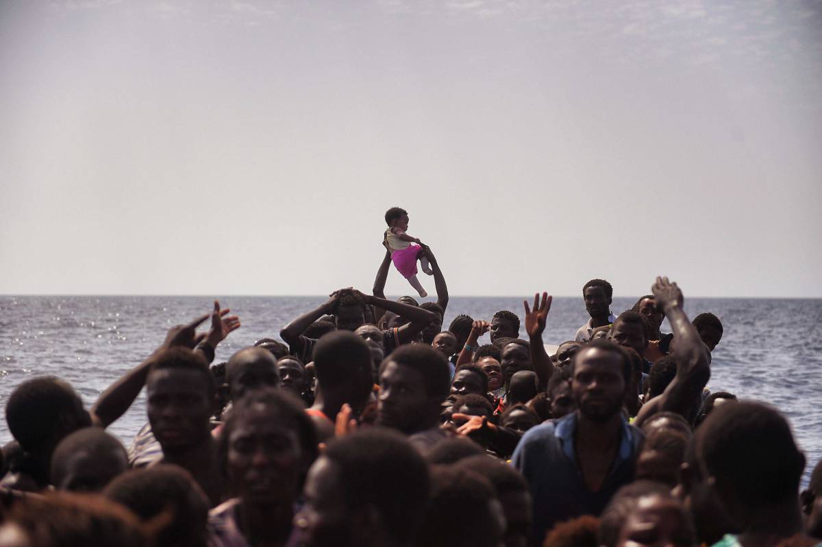 TOPSHOT - Migrants wait to be rescued by members of Proactiva Open Arms NGO in the Mediterranean Sea, some 12 nautical miles north of Libya, on October 4, 2016. At least 1,800 migrants were rescued off the Libyan coast, the Italian coastguard announced, adding that similar operations were underway around 15 other overloaded vessels. / AFP PHOTO / ARIS MESSINISARIS MESSINIS/AFP/Getty Images