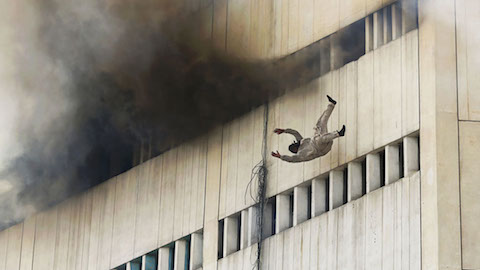 A man falls from a high floor of a burning building in central Lahore