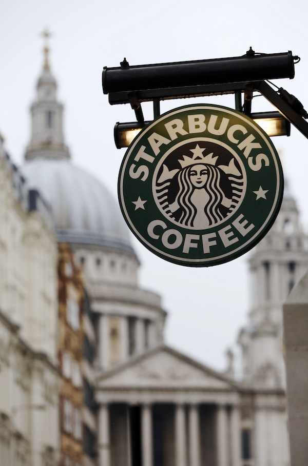 St Paul's Cathedral is pictured behind a signage for a Starbucks coffee shop in London October 8, 2012. Picture taken October 8, 2012.   To match Special Report BRITAIN-STARBUCKS/TAX      REUTERS/Luke Macgregor (BRITAIN - Tags: BUSINESS RELIGION LOGO) - RTR395SX