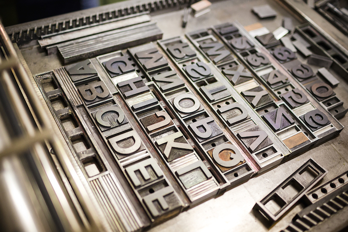 Old typography printing machine with font characters for craftman typography